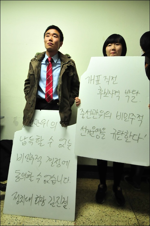 2. 김진겸 정치대 회장 당선자와 이수정 문과대 회장 당선자가 중선관위의 결정에 납득하지 못하겠다는 피켓으로 시위하고 있다.