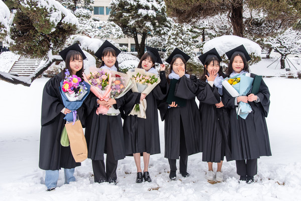 우리의 청춘을 기념하며 우리 대학 행정관 앞에서 졸업생들이 꽃다발을 들고 예쁜 미소를 짓고 있다./사진·박지우 기자