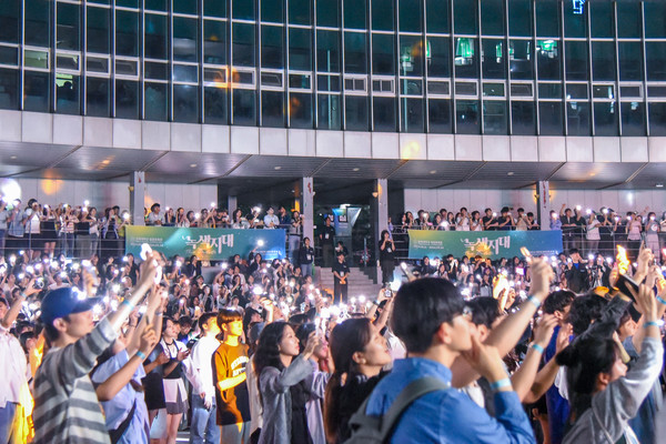 함께 아름다운 별을 이루다 노천극장에서 무대를 보는 학우들이 휴대전화 손전등으로 무대를 비추고 있다./사진·박지우 기자