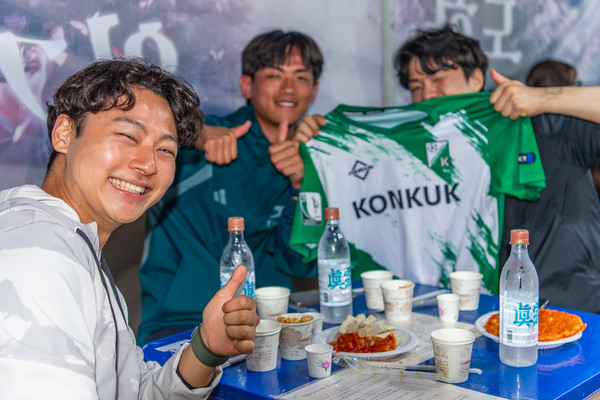 유니폼과 함께 녹색 건국! 주점을 이용하는 학우가 건국이 새겨진 유니폼을 들고 사진을 촬영하고 있다./사진·원예진 기자