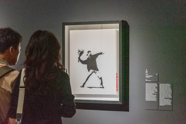 지난 2일, 관란객이 충무아트센터 갤러리에 전시된 뱅크시의 '사랑은 공중에(흑백)' 작품을 살펴보고 있다.ⓒBanksy/사진·박솔 기자